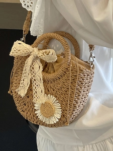 Woven straw crossbody bag with white lace bow and daisy detail on white dress