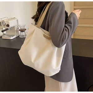 Detail of white tote bag featuring a leather FASHION label and khaki wide shoulder strap