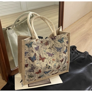Vue détaillée du sac cabas tissé orné de motifs colorés de papillons et de plantes