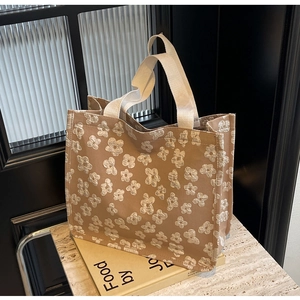 Close-up of floral jacquard canvas tote bag on a book with marble background