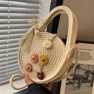 Handgefertigte beige runde Strohtasche mit Blumen und Spitzenschleife für Strandreisen