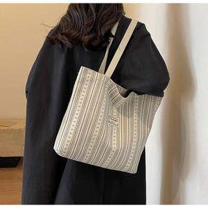 Lifestyle shot of large corduroy tote bag showing capacity and striped canvas texture
