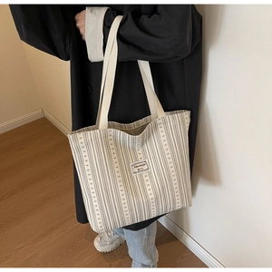 Detailed side view of a large capacity corduroy tote bag with black and white stripes