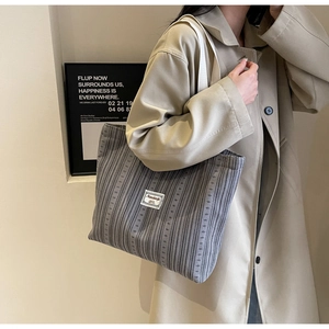 Detail of gray corduroy tote bag with vertical stripes and stylish polka dot pattern