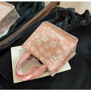 Detailed macro shot of the pink canvas tote bag with 3D white floral embroidery and gold snap