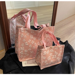 Detailed view of pink floral jacquard tote bags with 3D embossed texture and canvas handles