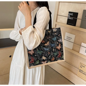 Détails du motif papillon en jacquard sur un grand sac cabas avec anses tressées