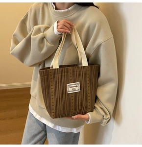 Detailed view of the dark brown corduroy tote bag with soft cream woven handles
