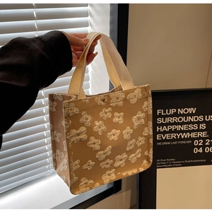 Detailed view of brown canvas tote bag with 3D floral embroidery and magnetic clasp