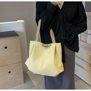 Detail of light yellow tote bag with FASHION label and卡其色 woven strap for school girls