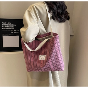 Close-up of pink striped corduroy tote bag showing fabric texture and brand label