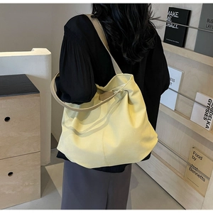 Detail of minimalist tote bag showing the FASHION leather tag and beige matte texture