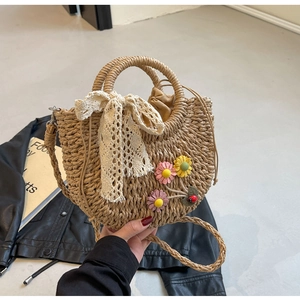 Close-up of handmade straw bucket bag with lace bow, crochet flowers and ladybug detail