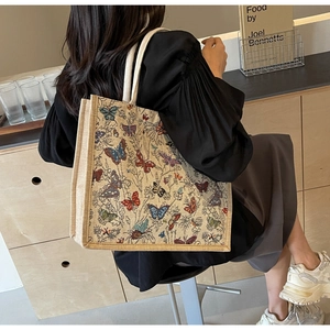 Grand sac cabas tissé avec motifs papillons colorés et anses en corde, style lifestyle