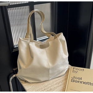 Detailed shot of white tote bag with flexible texture and stylish Fashion label