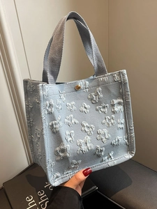 Light blue canvas tote bag featuring dense 3D floral textures and golden snap closure