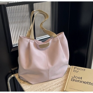 Detail of light pink tote bag with FASHION label on marble surface and glass background