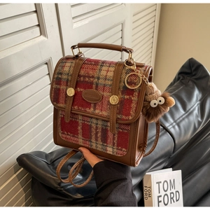 Nahaufnahme des Retro-Karo-Rucksacks mit Lederbesatz und goldener Schnalle