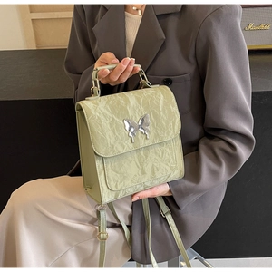 Détail du sac à dos en cuir plissé vert clair avec boucle papillon argentée