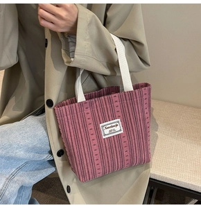 Detail of pink canvas tote bag featuring vertical stripes and Nanxiaojie brand label