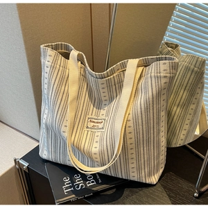 Detailed mirror view of large blue and white striped corduroy tote bag for work