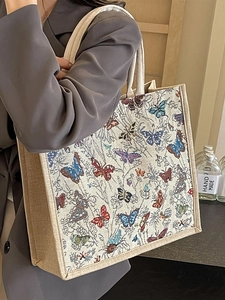 Grand sac cabas en toile avec imprimés papillons pour femme porté à l'épaule sur modèle