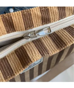 Nahaufnahme von Silberreißverschluss und gestreifter Cord-Stofftextur der Tasche