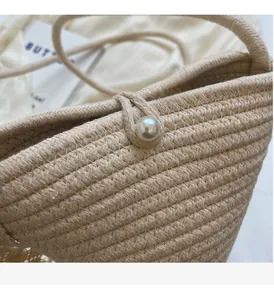 Detailed view of handmade woven straw bag with elegant pearl button and durable texture
