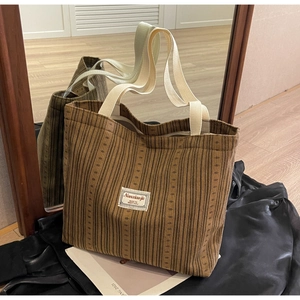 Detail of brown corduroy tote bag showing ribbed texture and Nanxiaojie logo label