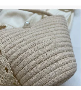 Detailed macro view of beige woven handbag with pearl fastener and delicate lace trim