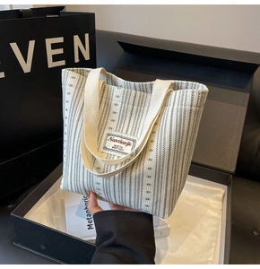 Detail of a vintage striped knit tote bag with brand label and stylish gift packaging