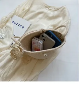 Interior view showing large capacity of the beige woven bag with pearl and bow detail