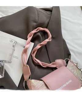 Détail de la bandoulière tressée rose et du tissu floral sur un sac baguette chic