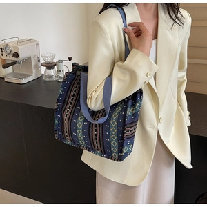 Ethnic style canvas tote bag with colorful geometric patterns shown in a lifestyle scene