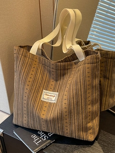Brown corduroy tote bag with wide white cotton straps and vintage minimalist design