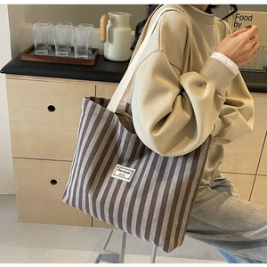 Detailansicht der großen braun-weiß gestreiften Canvas-Tragetasche in minimalistischem Design