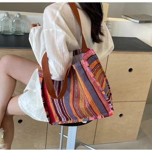 Detail of colorful woven tote bag with ethnic stripes and brown shoulder straps