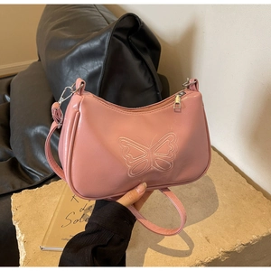 Detail der Schmetterlingsstickerei auf einer rosa Baguette-Tasche aus PU-Leder mit Silberdekor