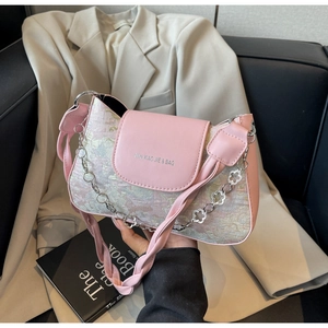Détail du sac baguette patchwork rose avec chaîne à fleurs argentées et logo de marque
