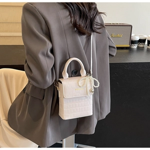 Chic cream-white crossbody bag with crocodile pattern and pearl bow charm detail