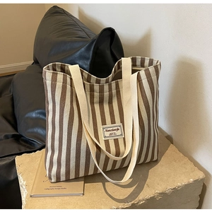 Detail der gestreiften Cord-Tasche mit strukturierter Textur und gewebtem Etikett