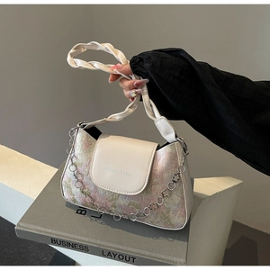 Details der Baguette-Tasche aus Blumenstoff mit Lederklappe und Blumenmetallkette