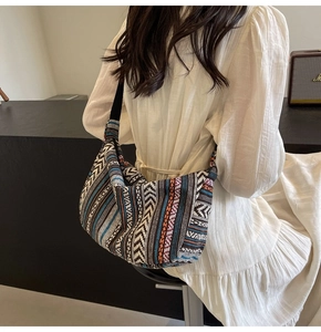 Détail de vue arrière d'un grand sac cabas ethnique coloré porté sur une robe blanche