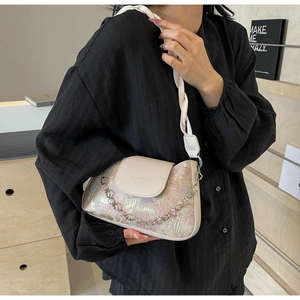 Détail du sac baguette avec texture jacquard florale et chaîne métallique élégante