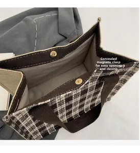 Detailed view of the invisible magnetic closure on a plaid canvas lunch tote bag