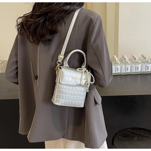 Detail of silver crocodile pattern mini handbag with pearl charm and metal logo