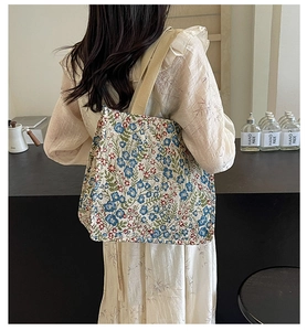Detailed shoulder view of a large floral canvas tote bag with thick durable straps