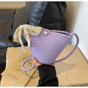 Detail of purple woven bucket bag with lace bow, pearl buckle and hand-knit texture
