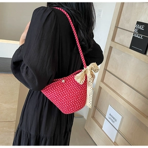 Detail of red and pink houndstooth handwoven bag with lace bow and pearl accent