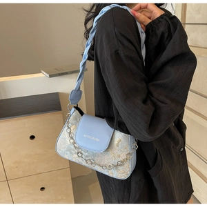 Details der hellblauen Baguette-Tasche mit goldenem Jacquard und silberner Blumenkette